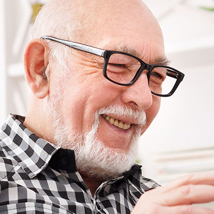 Elderly man smiling in a bright room