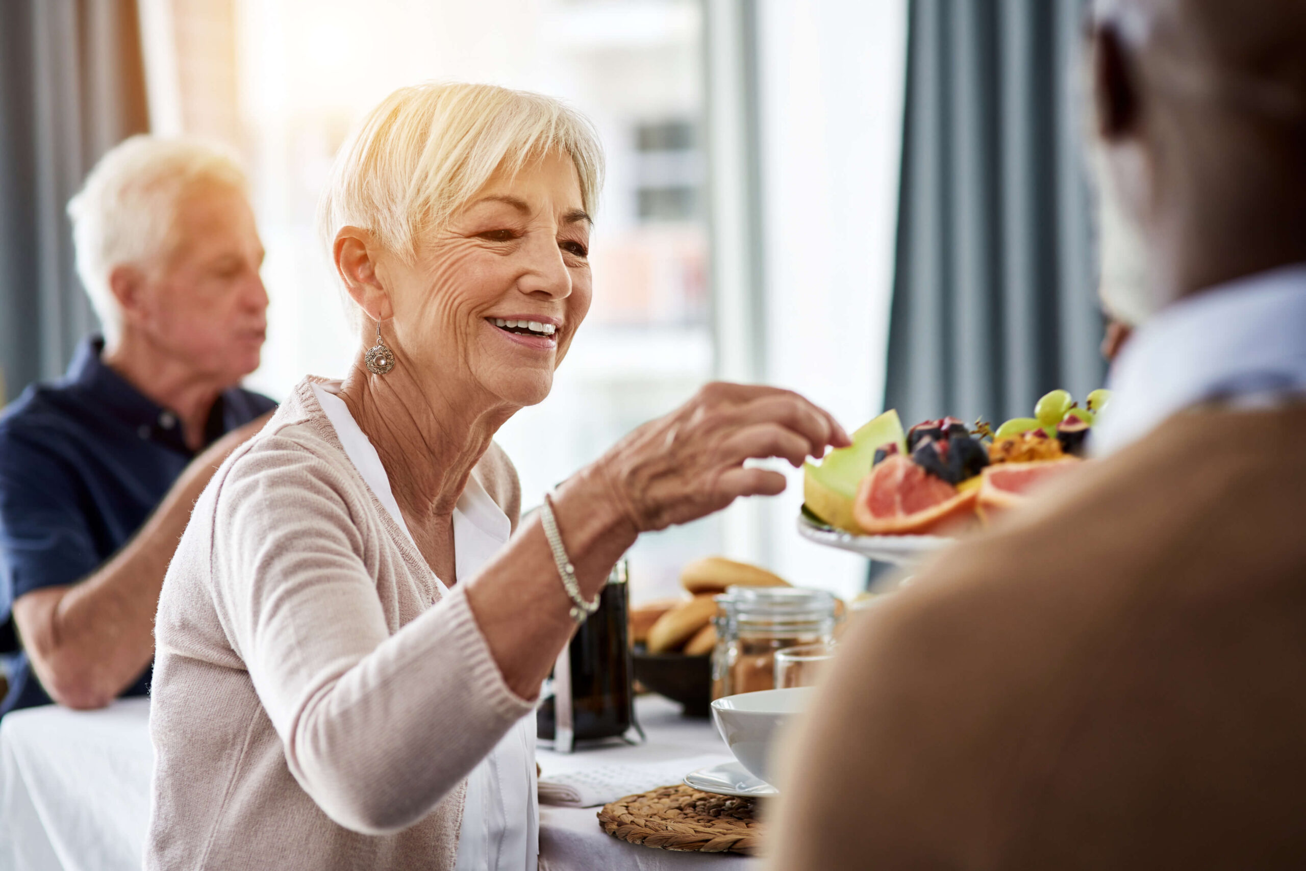 Resident enjoying fruit at a dining table