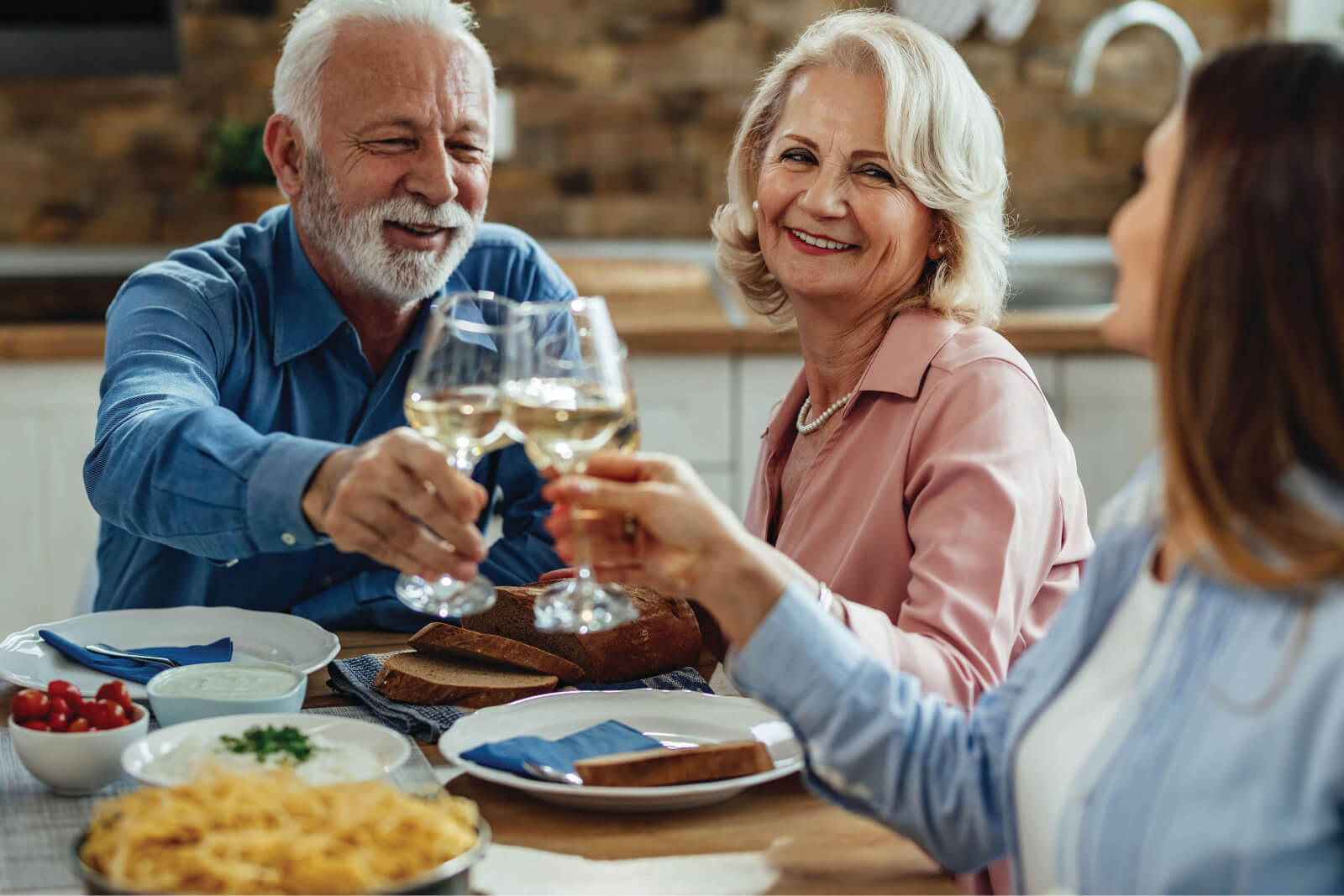 Residents enjoying a meal and toasting with glasses.