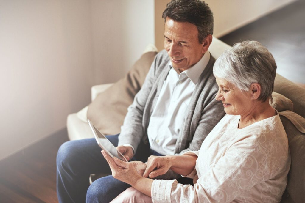Two residents using a tablet in a cozy common area