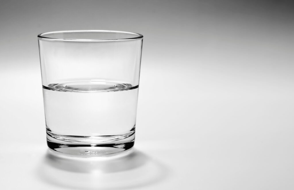 A glass of water on a plain background