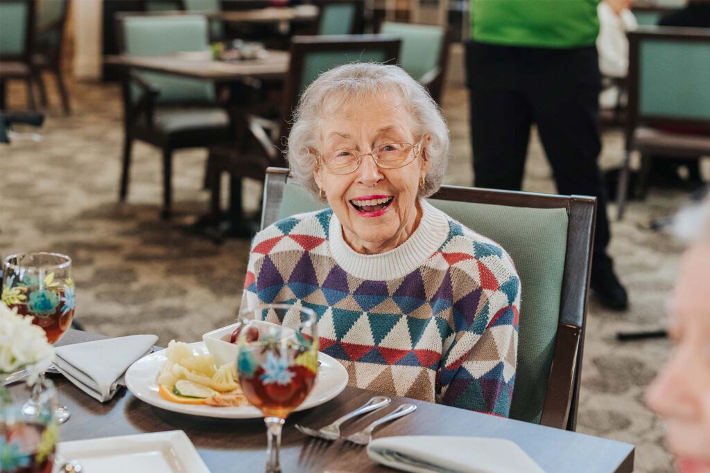 Resident enjoying a meal with a joyful expression