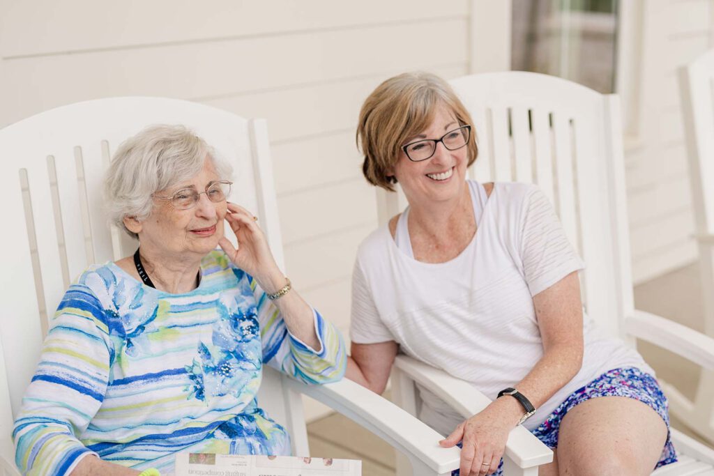 Two women enjoying conversation on a porch