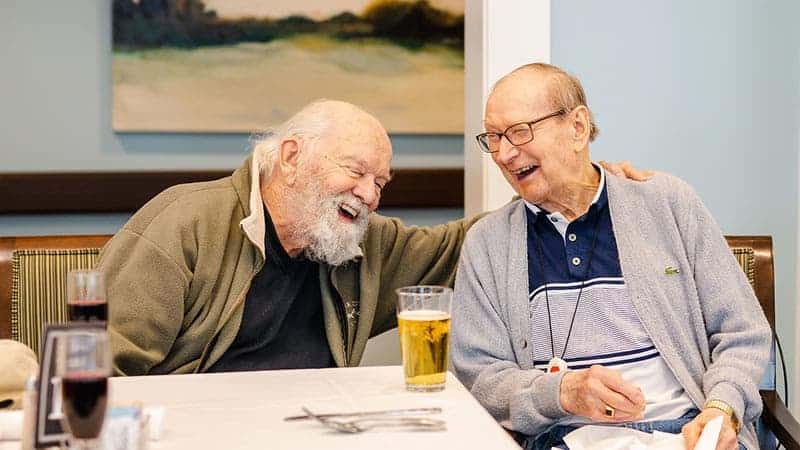 Two residents laughing together in a communal area