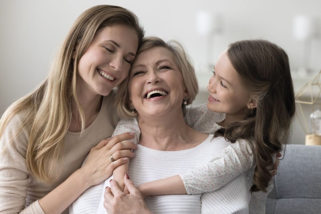Three generations smiling together in a cozy living space