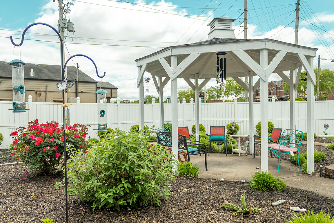 Outdoor gazebo with seating and garden flowers