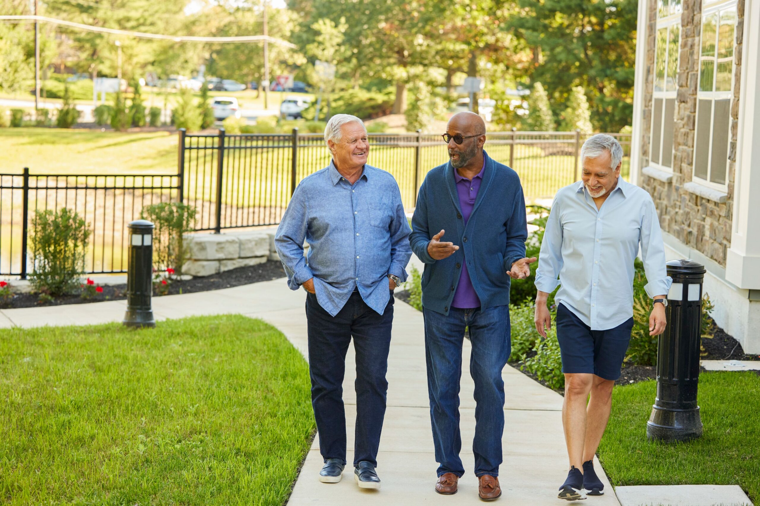 Three residents walking along a garden path