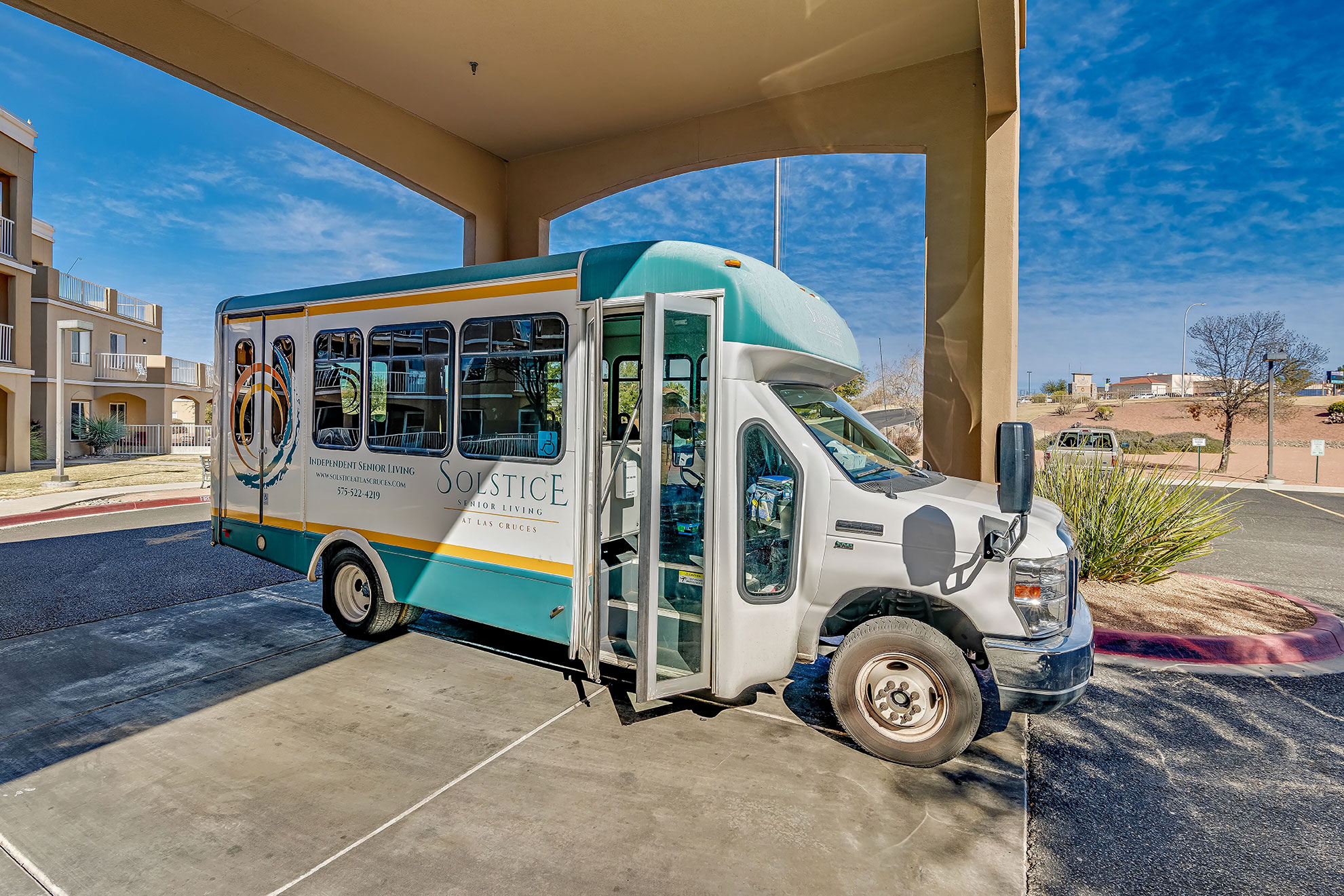 Facility shuttle bus parked under entrance