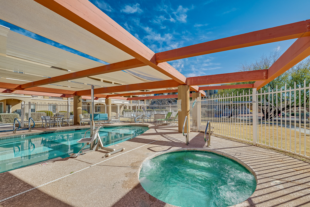 Outdoor pool area with jacuzzi and lounge chairs