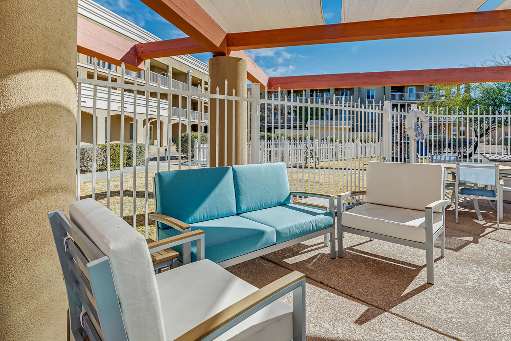 Outdoor seating area with chairs and a fence