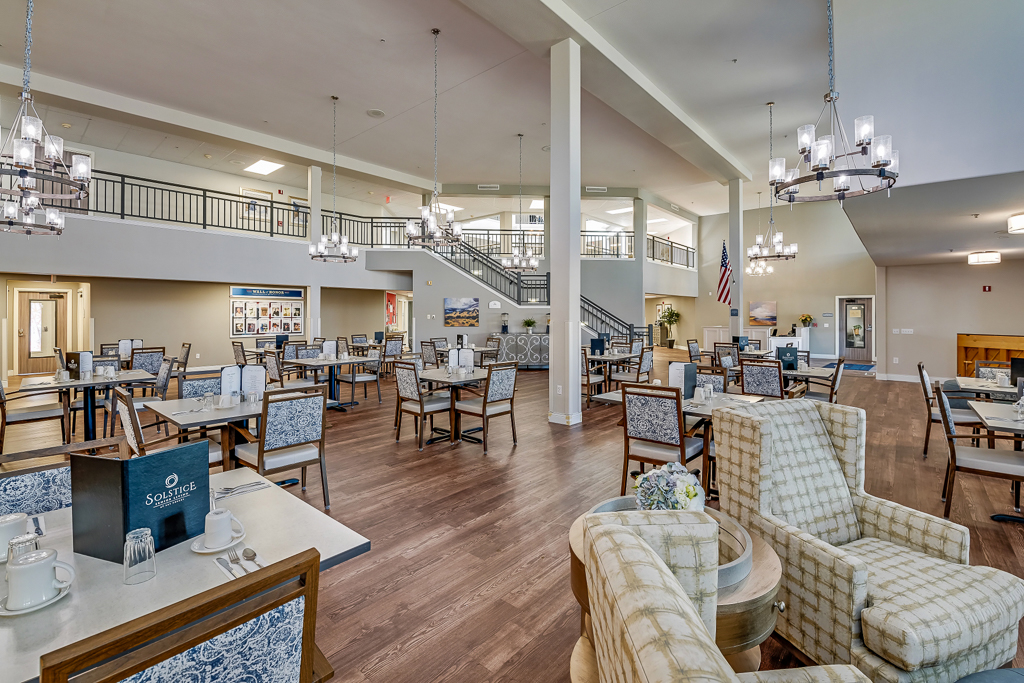 Dining area with tables and chairs in a senior living facility.