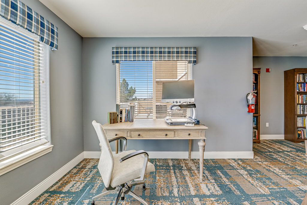 Well-lit interior with a desk and bookshelf.
