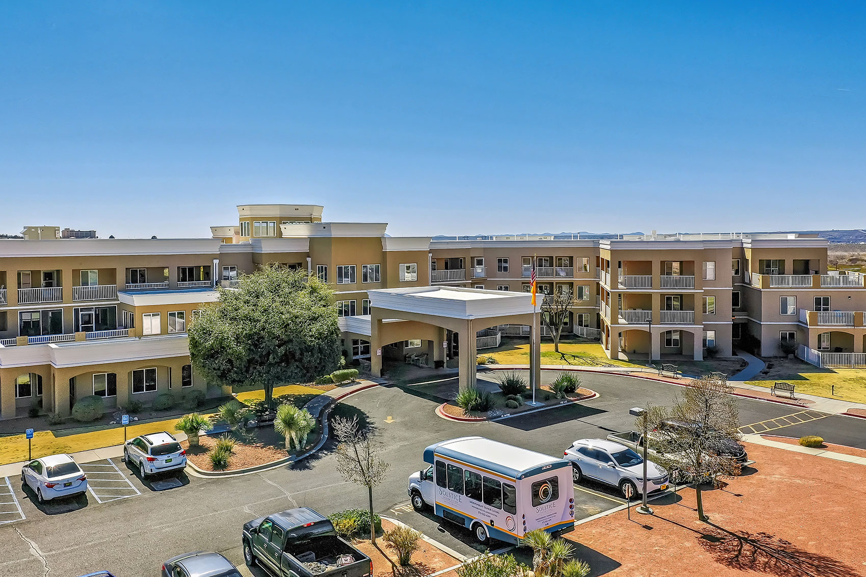 Exterior view of the facility with landscaping and vehicles.
