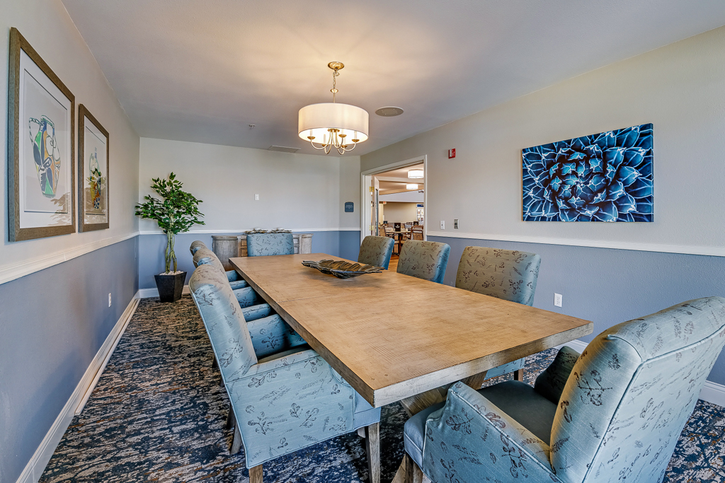 Dining area with a large table and decorative art.
