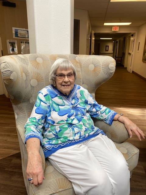 Resident smiling in a cozy armchair