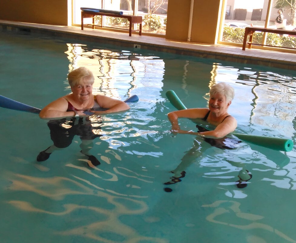 Two women enjoying water exercise in the pool.