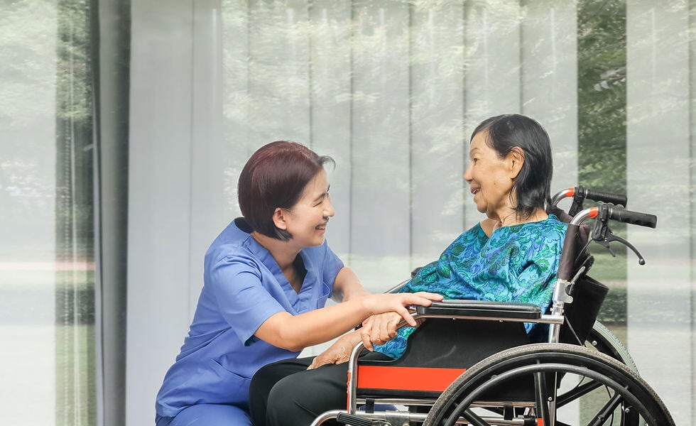 Caregiver interacting with a senior in a wheelchair.