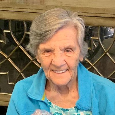 A smiling senior woman in a blue jacket.