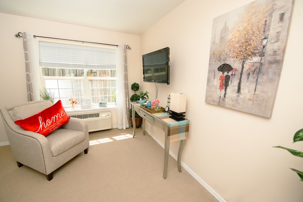Cozy room with comfortable furnishings and artwork.