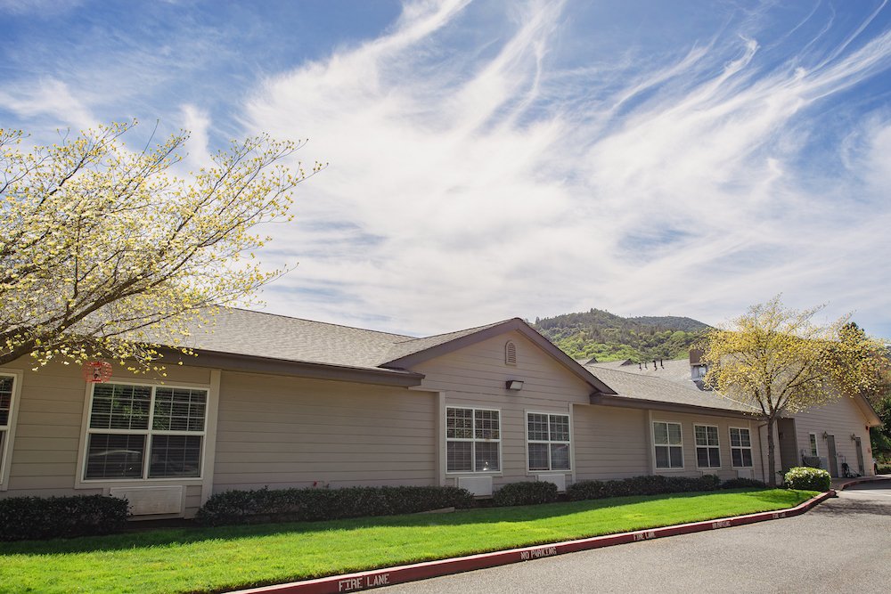 Exterior view of a nursing home with gardens.