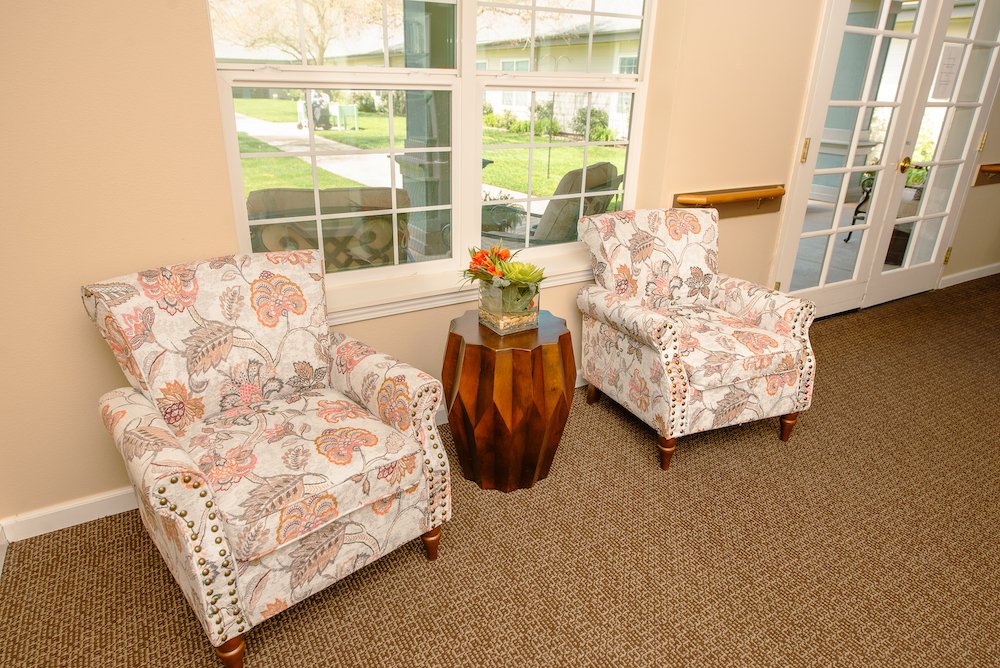 Cozy lounge area with floral chairs and a side table.