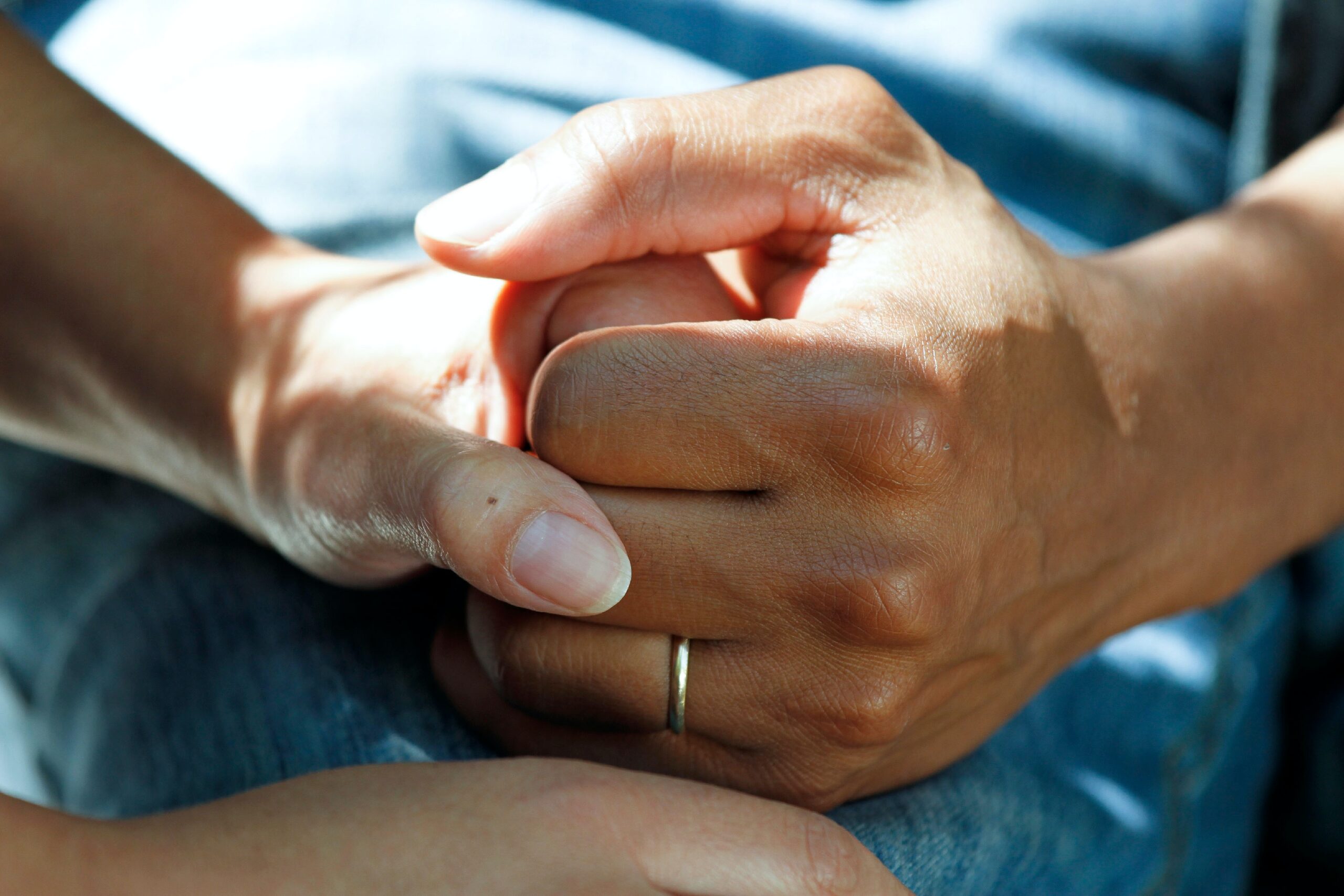 Close-up of two hands holding each other.