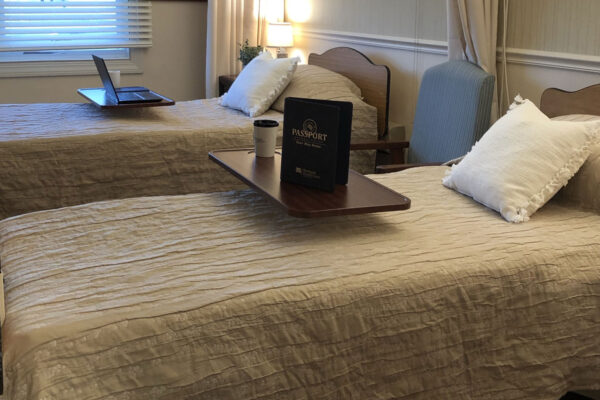 Cozy resident room with twin beds and a table.