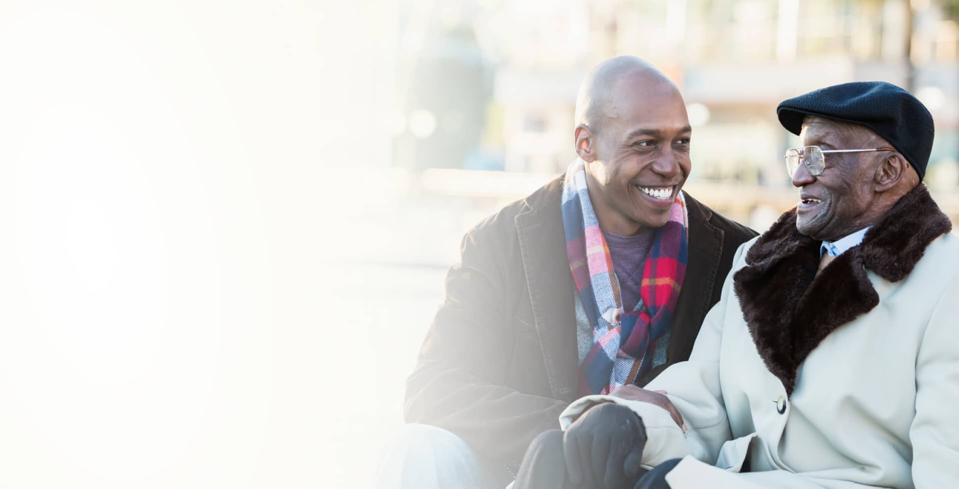 Two older men sharing a joyful moment outdoors.