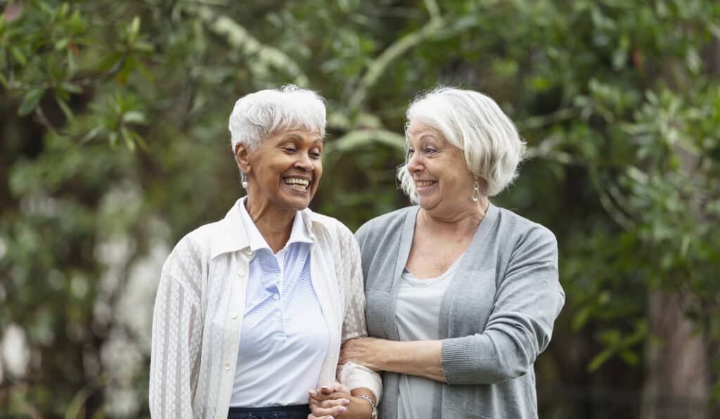 Two seniors smiling outdoors together