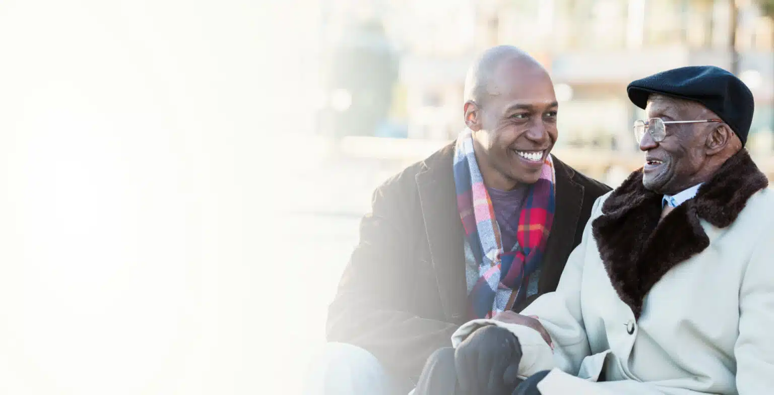 Senior man with family member in an outdoor setting.