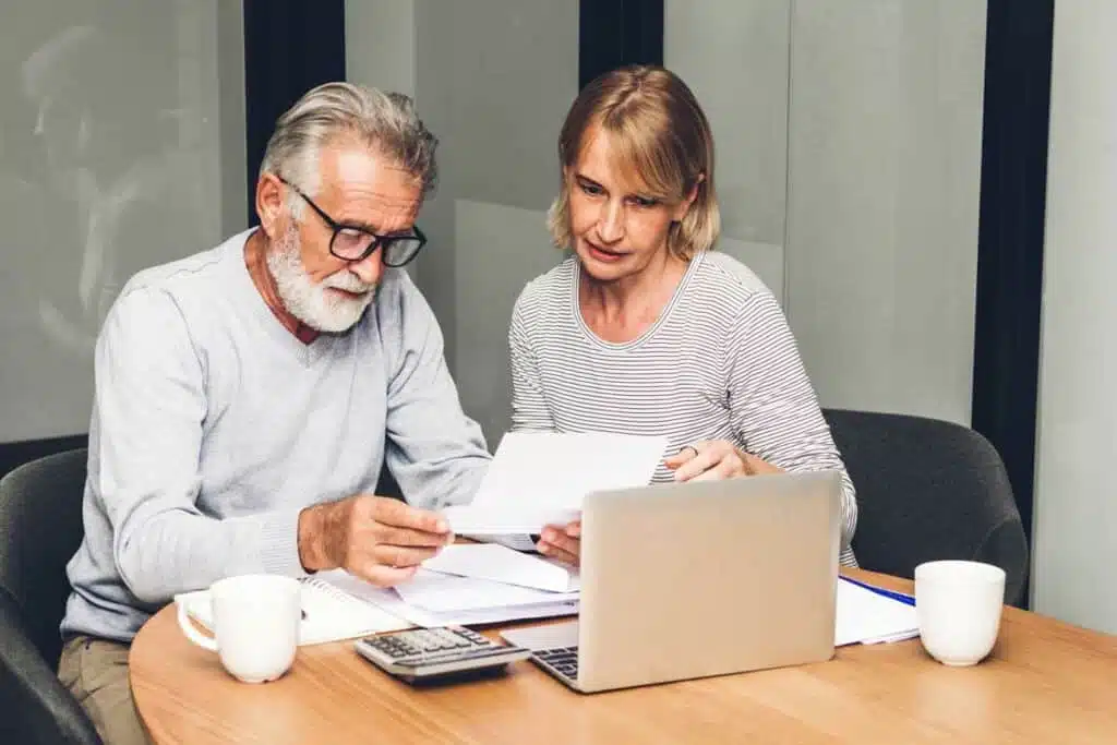 Two seniors reviewing documents at a table
