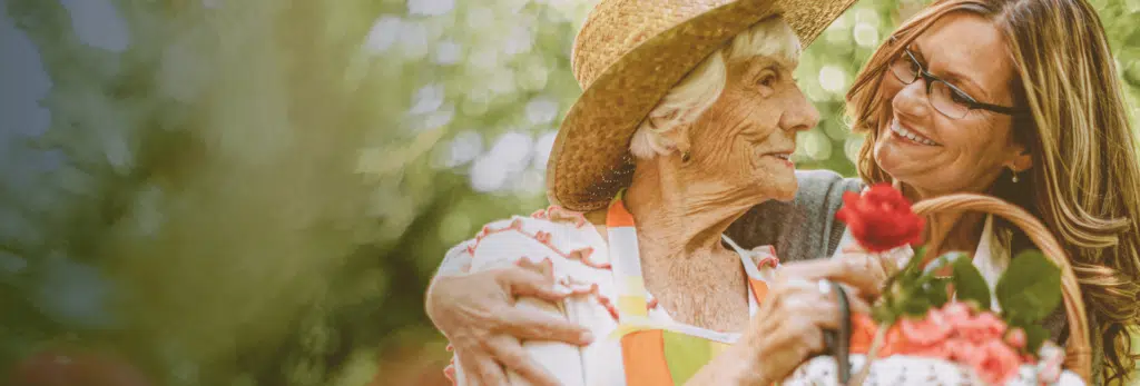 Senior woman enjoying time with caregiver outdoors.