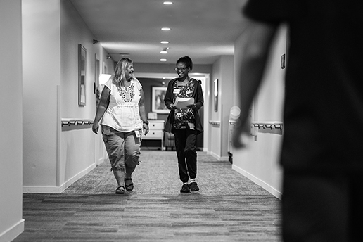 Two staff members walking in a hallway