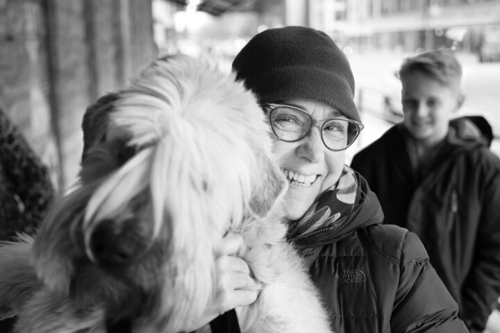 Smiling woman holding a dog outdoors