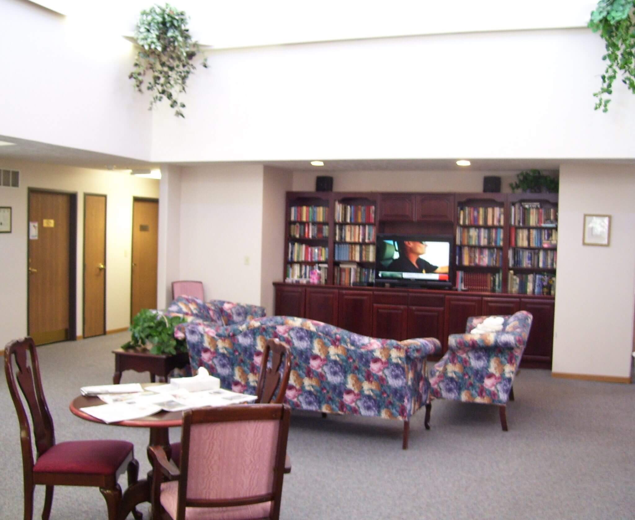Common area with floral sofas and bookshelves