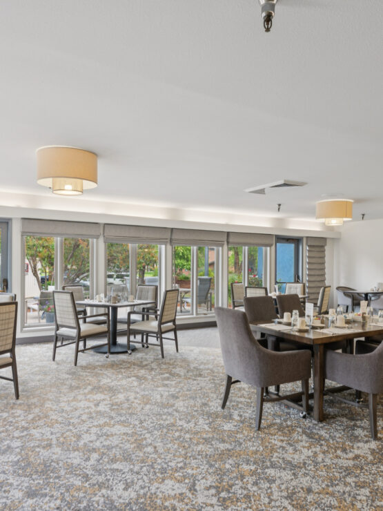 Brightly lit dining area with tables and chairs.