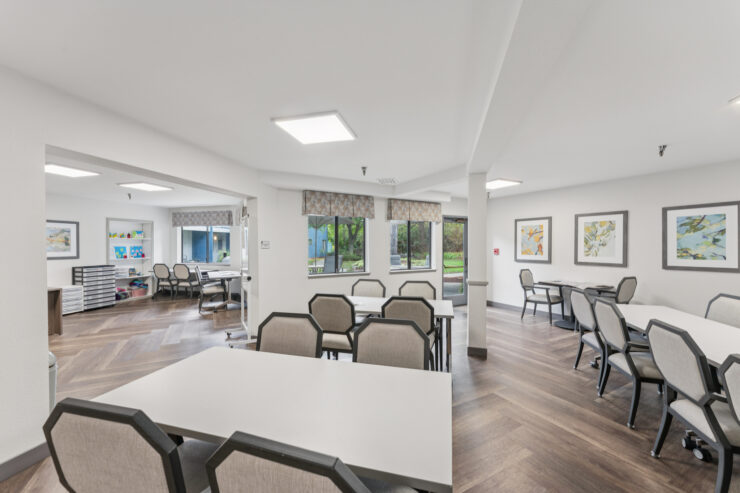 Common area with tables and chairs for activities.