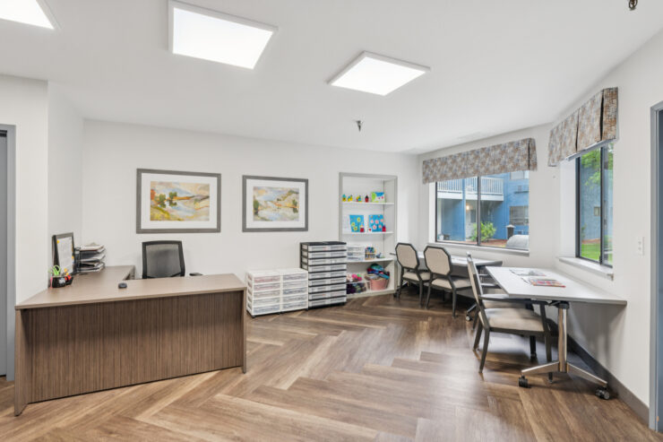 Bright and welcoming common area with desks and art.