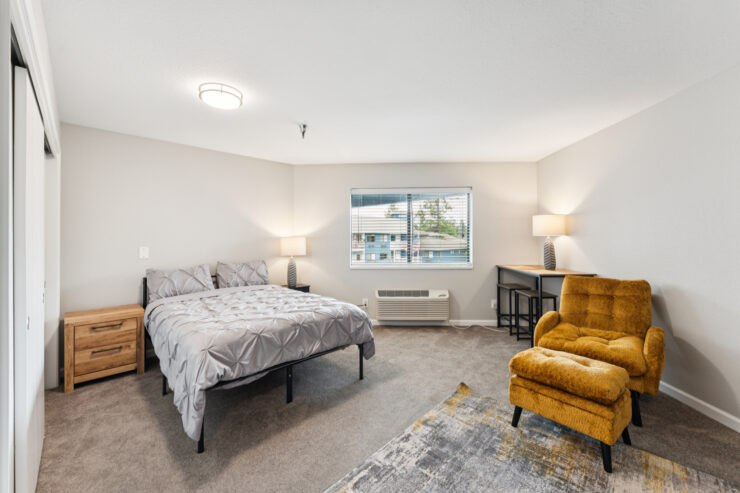 Well-furnished resident room with a bed and seating area.