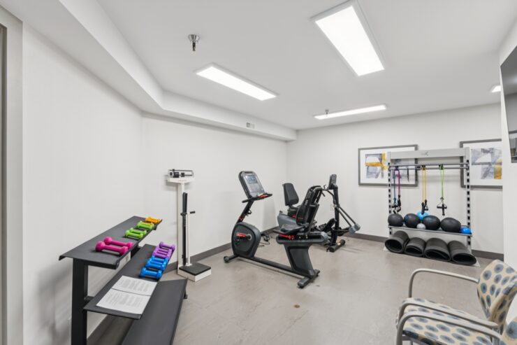 Interior fitness area with exercise equipment and weights.