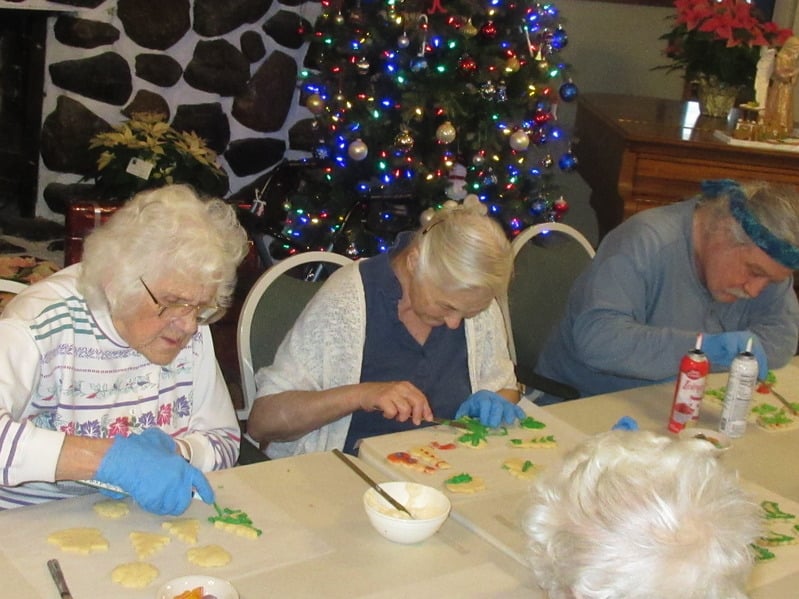 Residents decorating cookies together during an activity.
