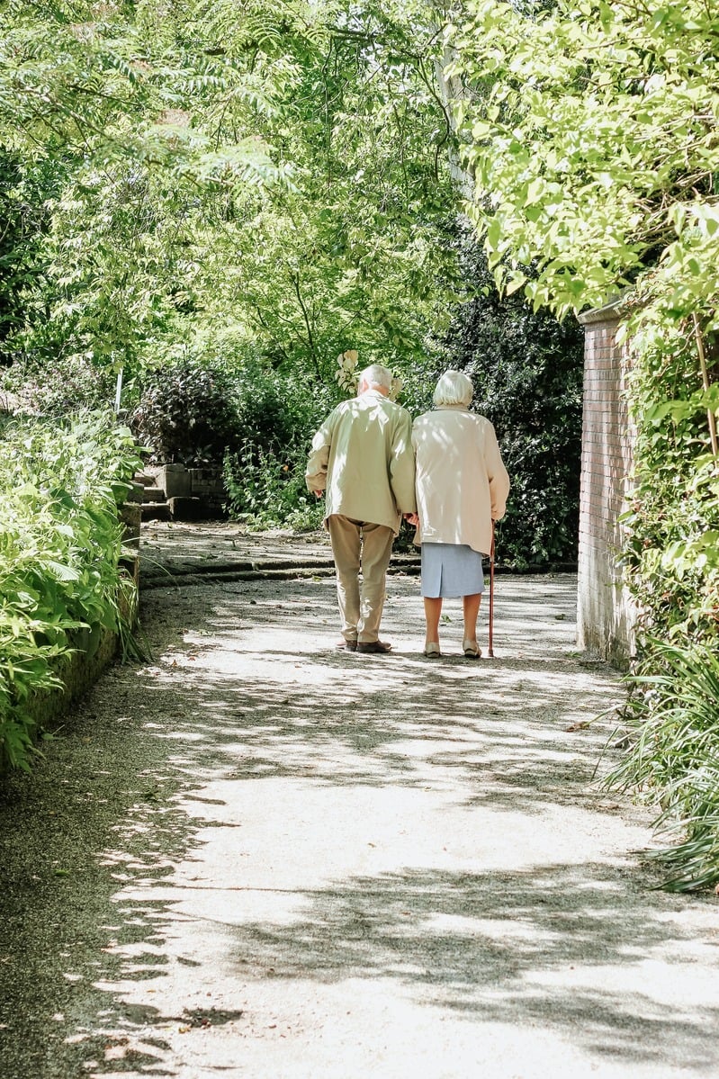 Elderly couple walking in a garden path