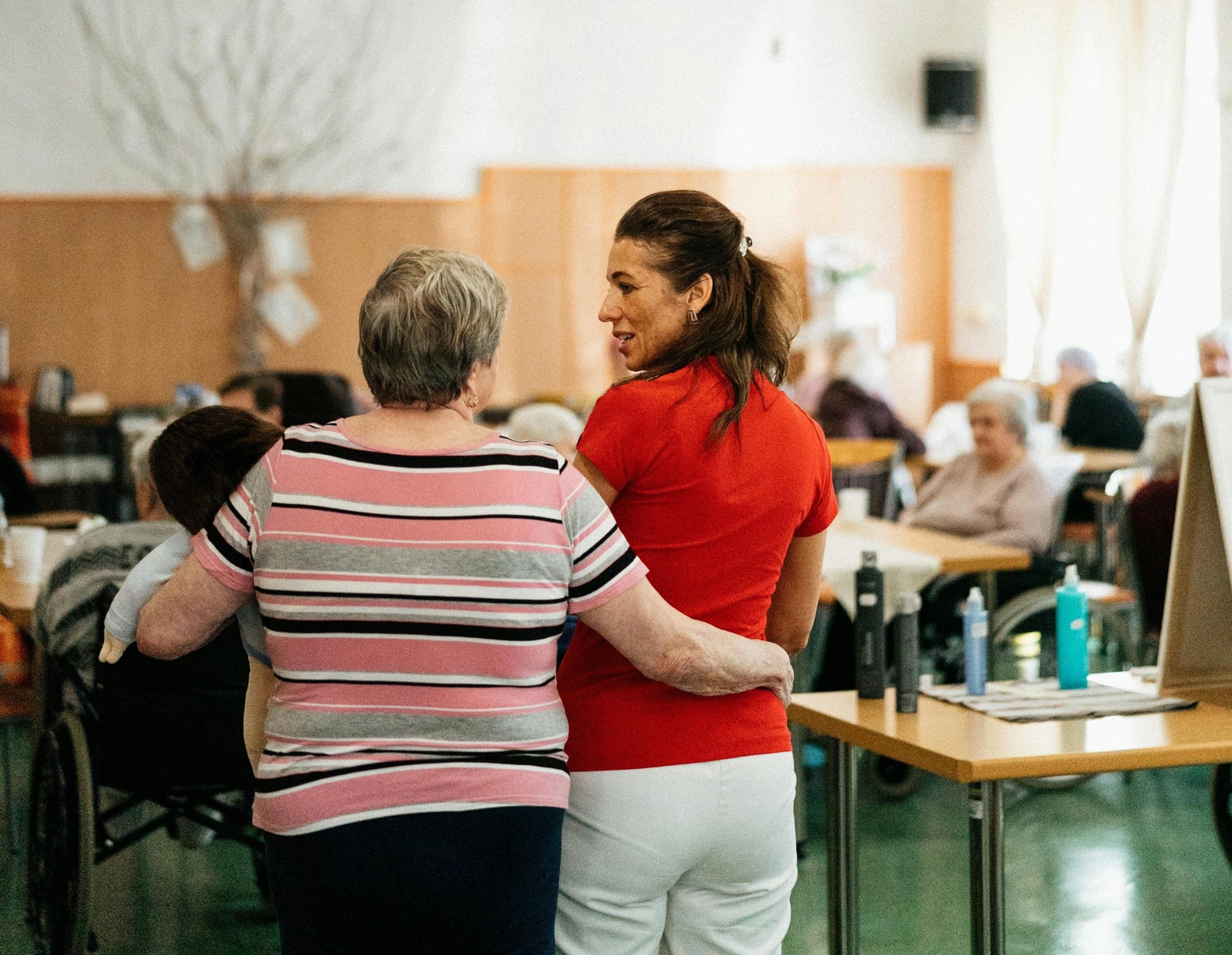 Care staff assisting residents in a common area.