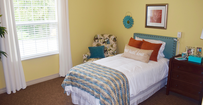 Cozy resident bedroom with a bed and chair.
