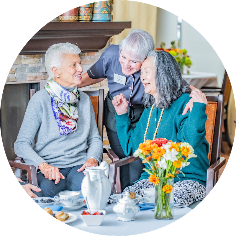 Residents enjoying interaction with staff in a cozy setting.