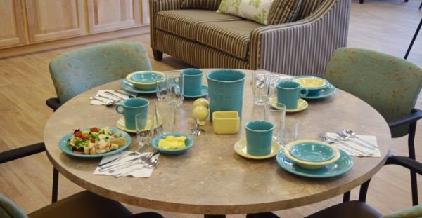 Dining table set with colorful dishes and food.