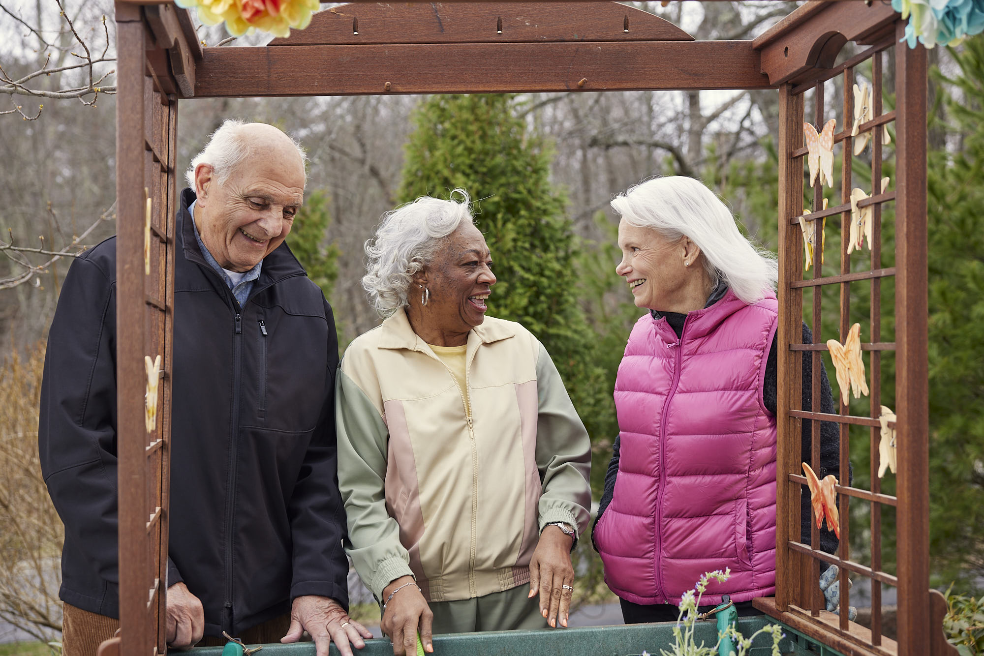 Three seniors enjoying time in a garden space.