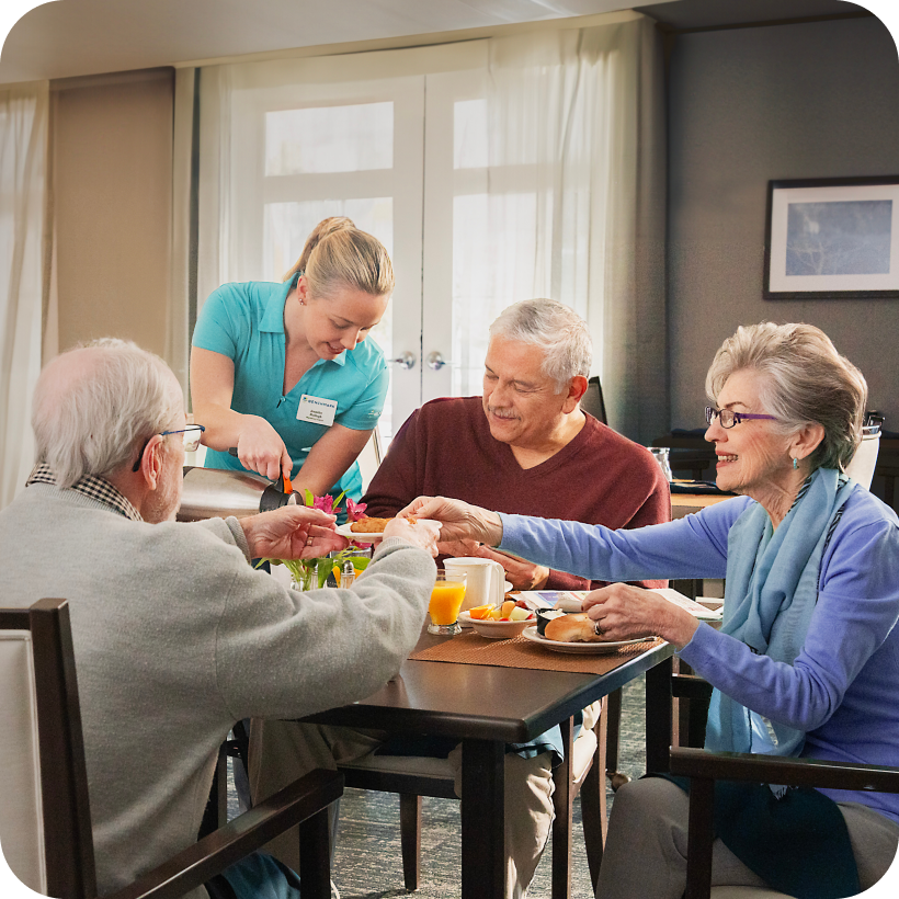 Residents and staff enjoying a meal together.