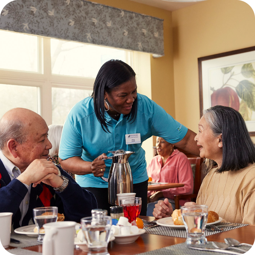 Staff serving residents during a meal.