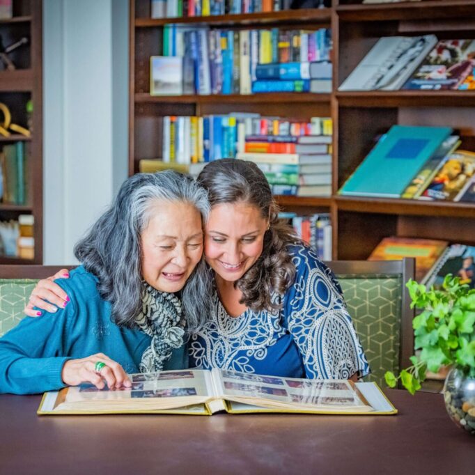Two women enjoying a photo album together.